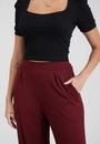 Calça Pantalona Com Bolso E Pregas Em Malha Canelada
